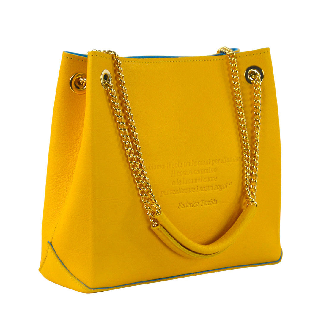 Yellow handbag with gold chain handles on a white background