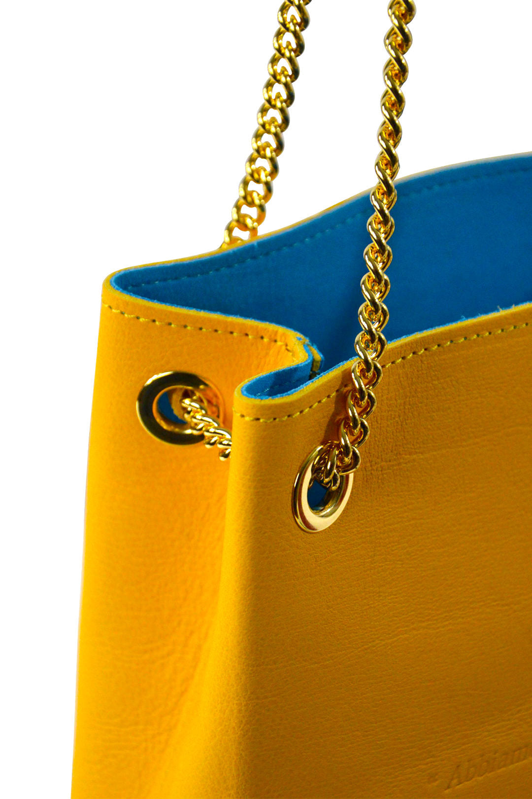 Yellow handbag with gold chain strap and blue interior on a white background